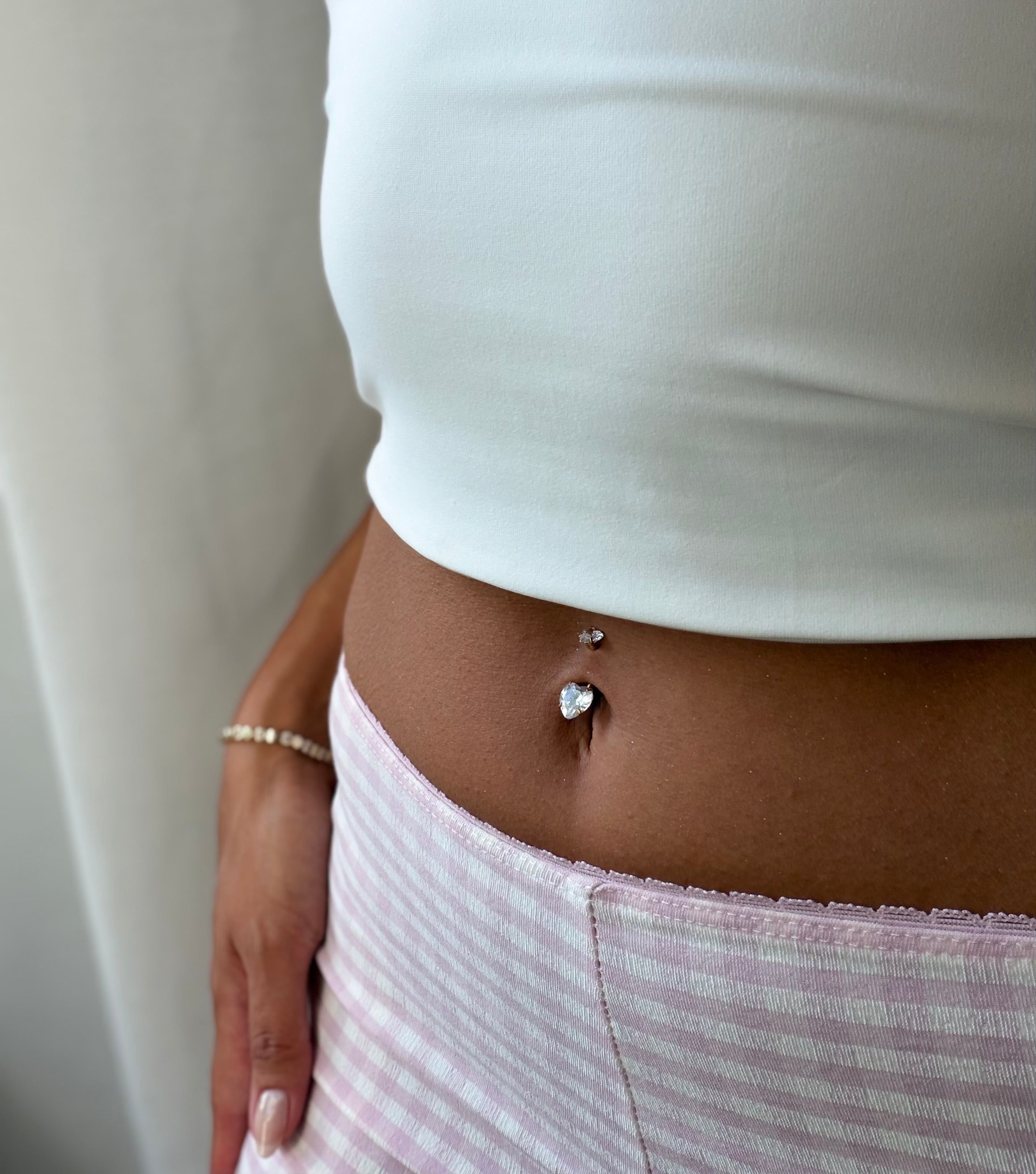 Funkelndes Herz-Bauchnabelpiercing