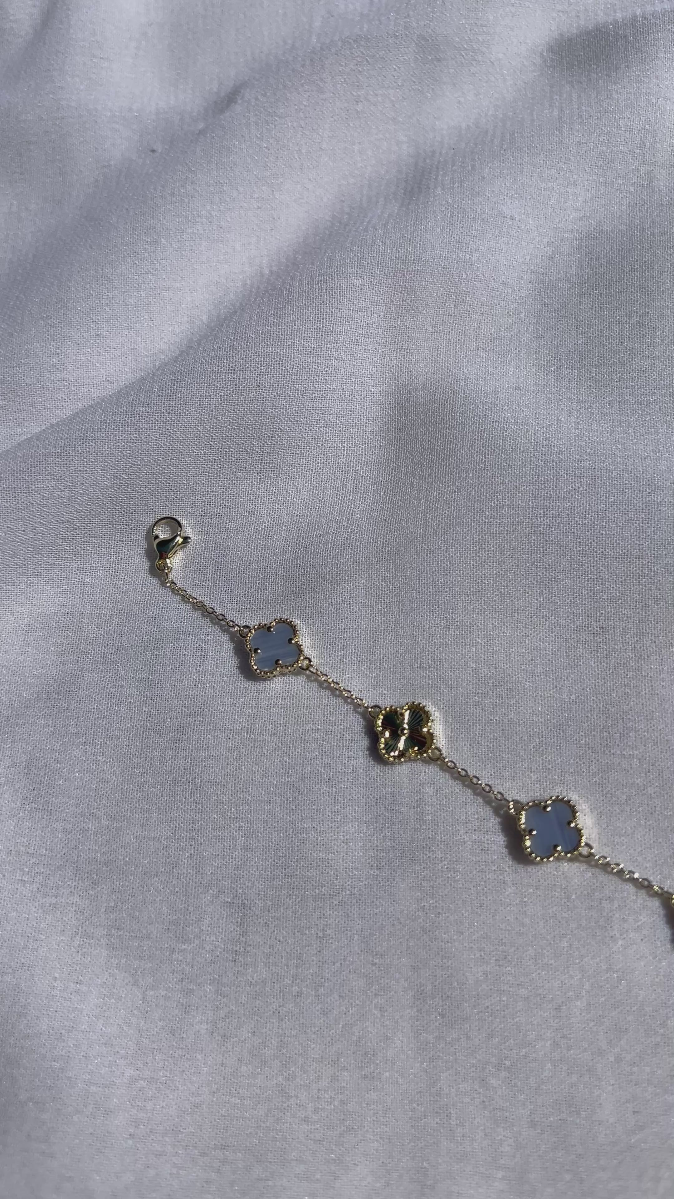 Goldfarbenes Kleeblatt-Armband mit abwechselnden hellblauen und goldenen Motiven